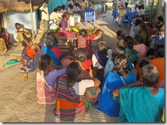Gathered around mother - women on one side, men on the other
