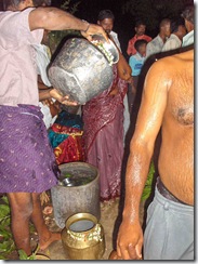 Pouring water to use in preparing the body