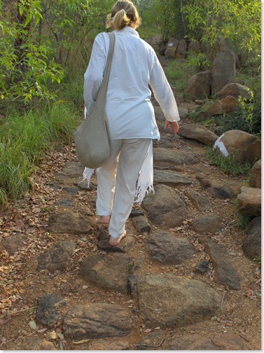 Carol walks barefoot up the path